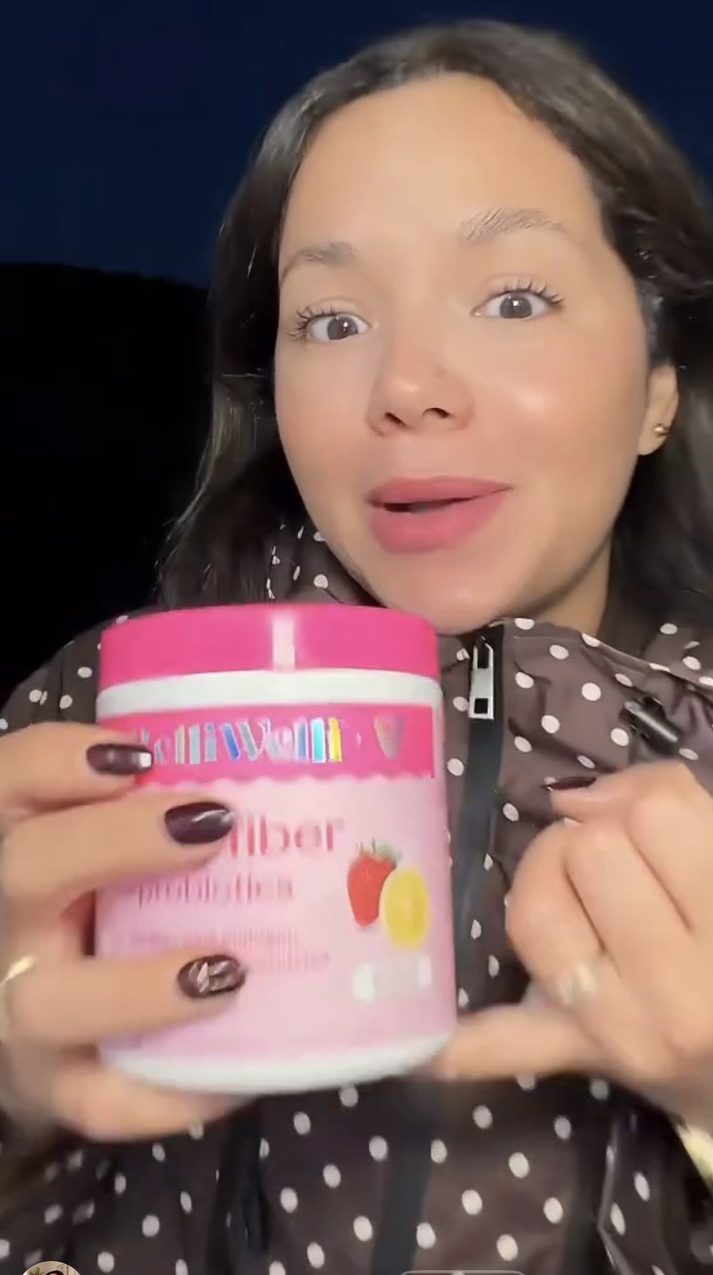 Smiling BelliWelli customer holding up a tub of Strawberry Lemonade fiber powder