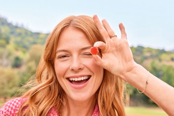 Woman winking while holding a gummy up to her eye