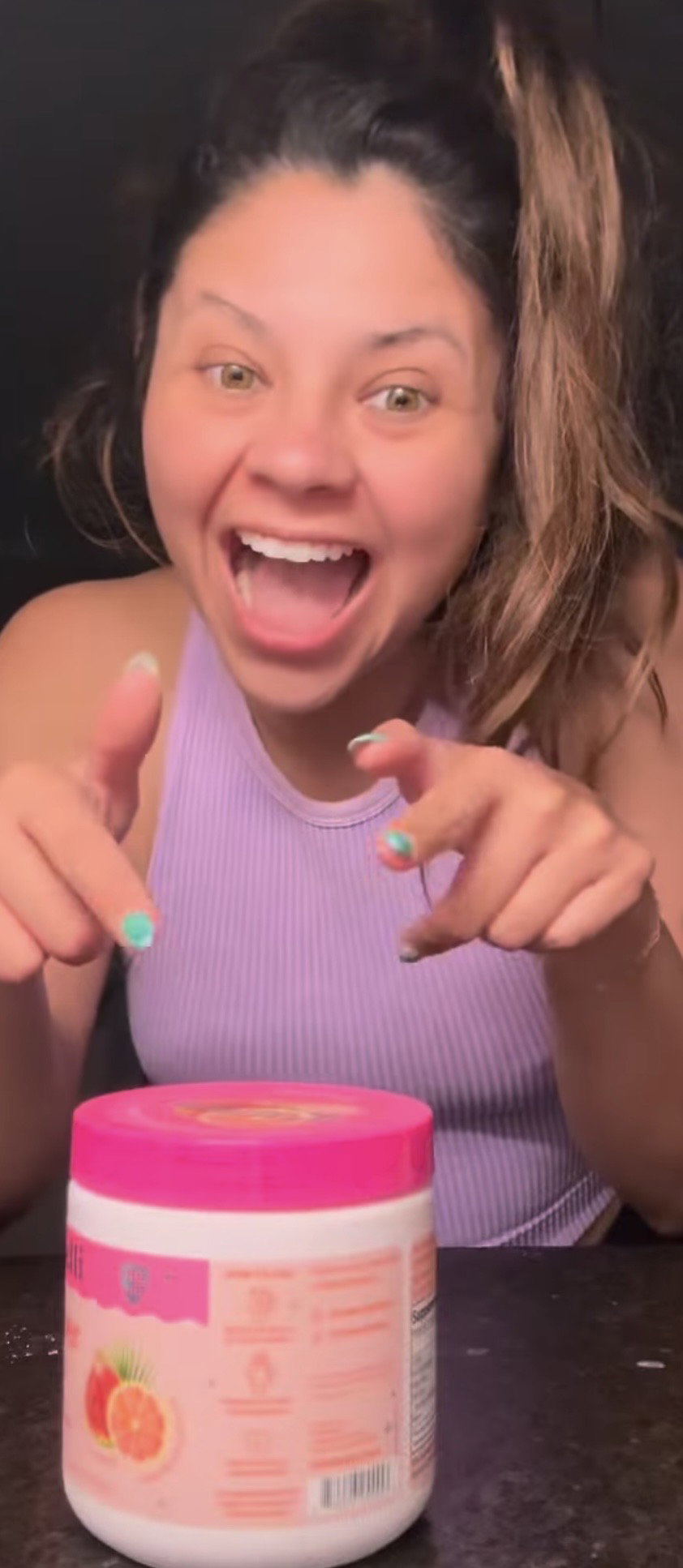 Excited BelliWelli customer pointing at her tub of fiber powder