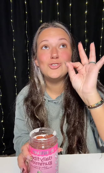 Influencer winking with a BelliWelli fiber gummy