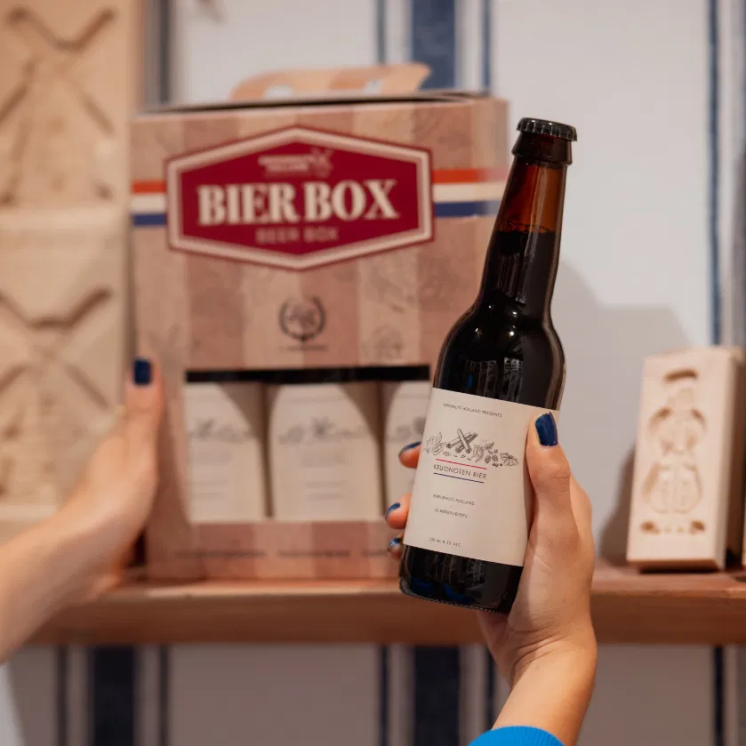 Hand houdt een fles Kruidnoten Bier voor de Peppernuts Bier Box