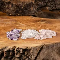 Drei Edelsteine: violett, klar und rosa, auf einer strukturierten Holzoberfläche.