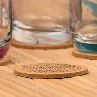 Korkuntersetzer unter Glastassen auf einer Holzoberfläche.