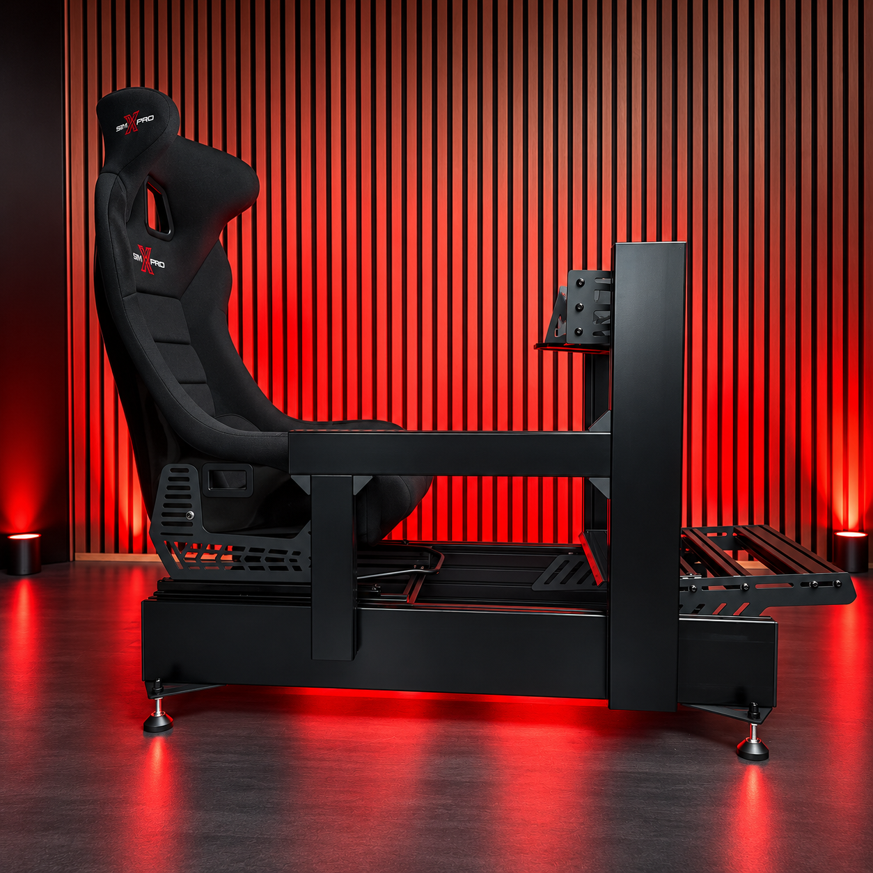 Side view of a SimXPro cockpit with black SimXPro bucket seat in a red-lit studio