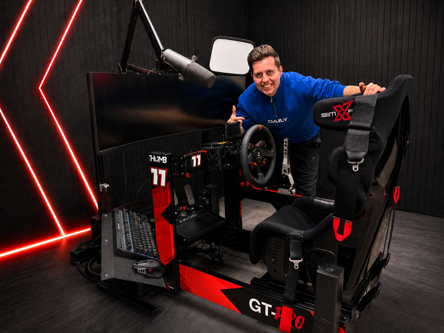 Content creator Thomb leaning on his SimXPro GT-PRO cockpit with red livery