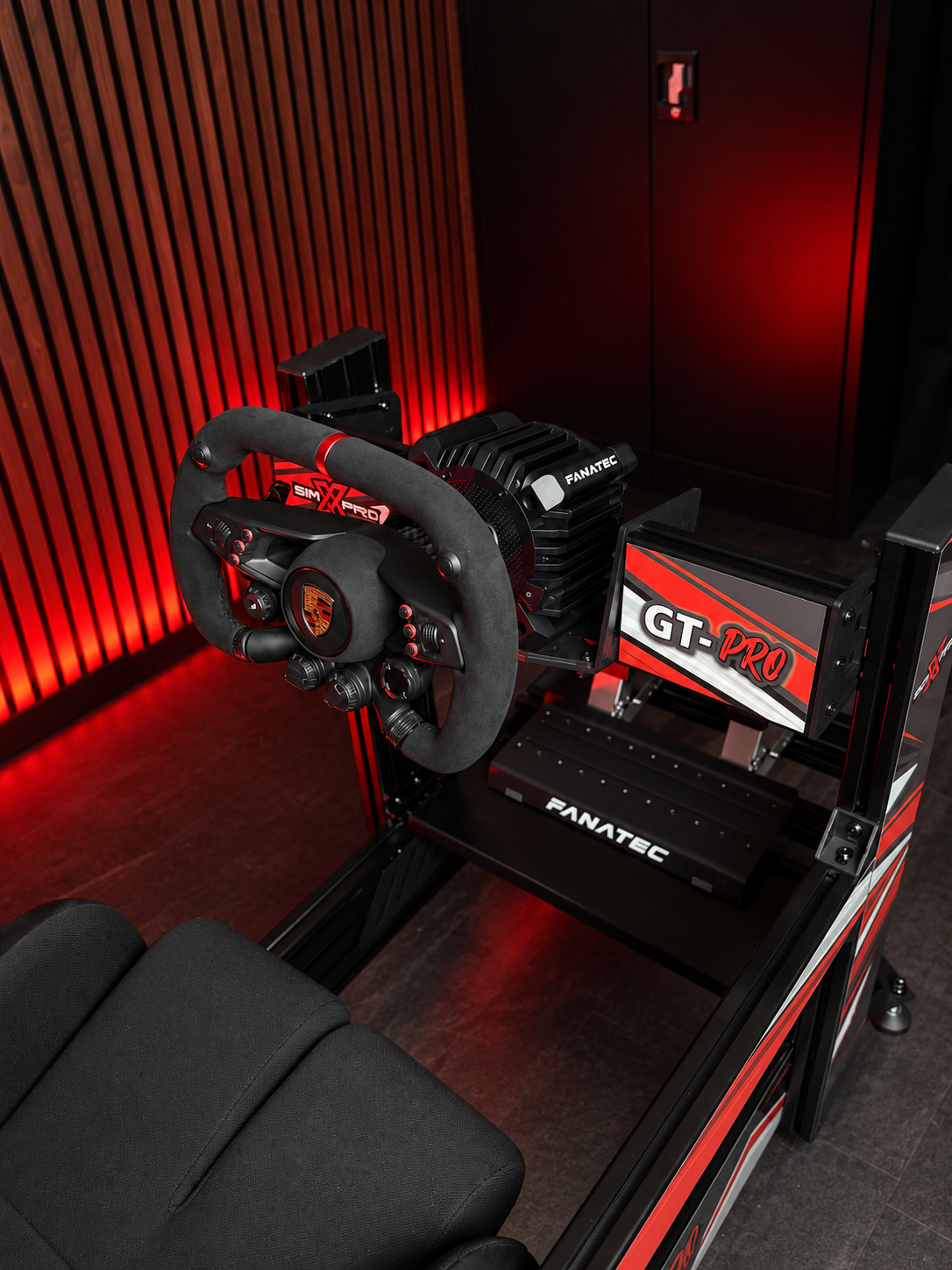 SimXPro GT-PRO cockpit with Fanatec wheelbase, steering wheel and pedals in a red-lit room