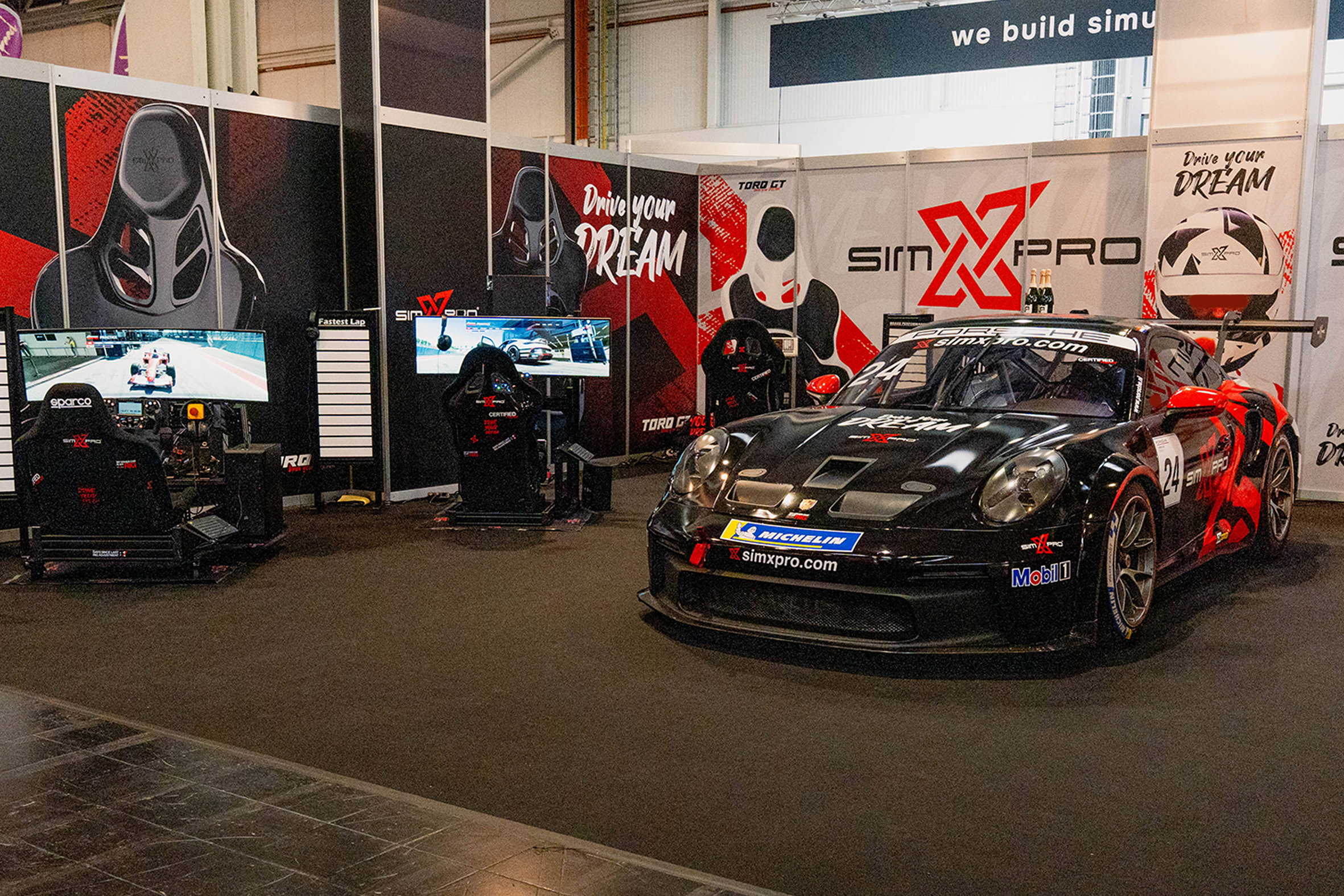 SimXPro stand with sim racing cockpits and the SimXPro Porsche 911 GT3 Cup race car