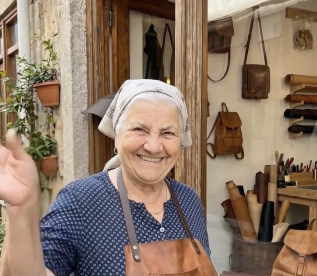 Nonna smiling outside her leather workshop