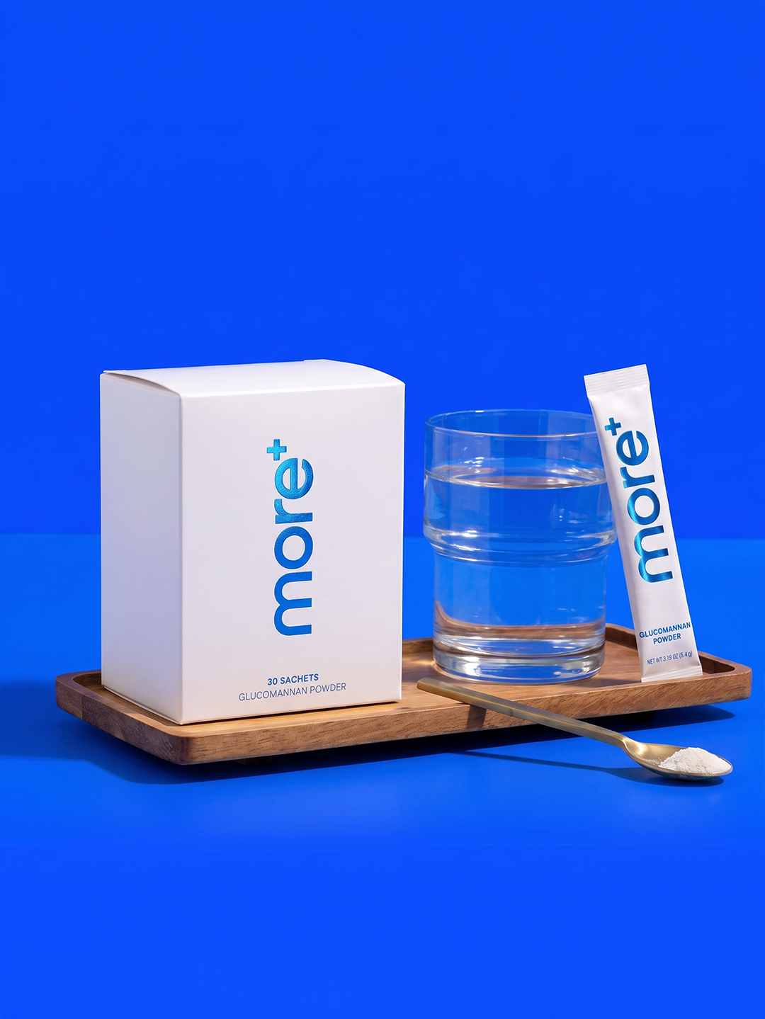 MORE+ 30-sachet box with a glass of water and a stick pack on a wooden tray