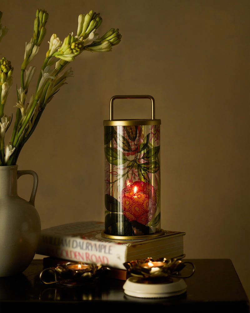 Brass lamp and candle holders glowing on a red lacquered console