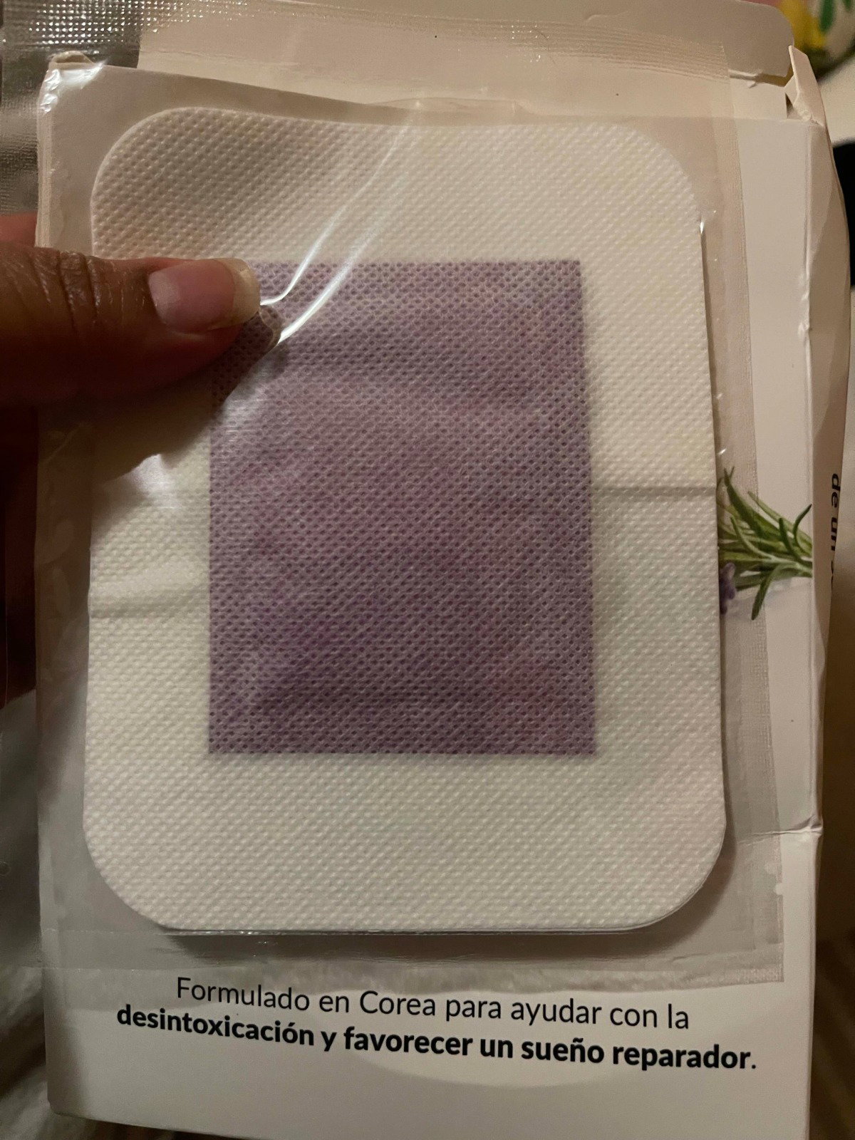 Customer photo holding a fresh SOONÉ lavender foot patch above its box, showing the pale purple herbal pouch on the white breathable strip.