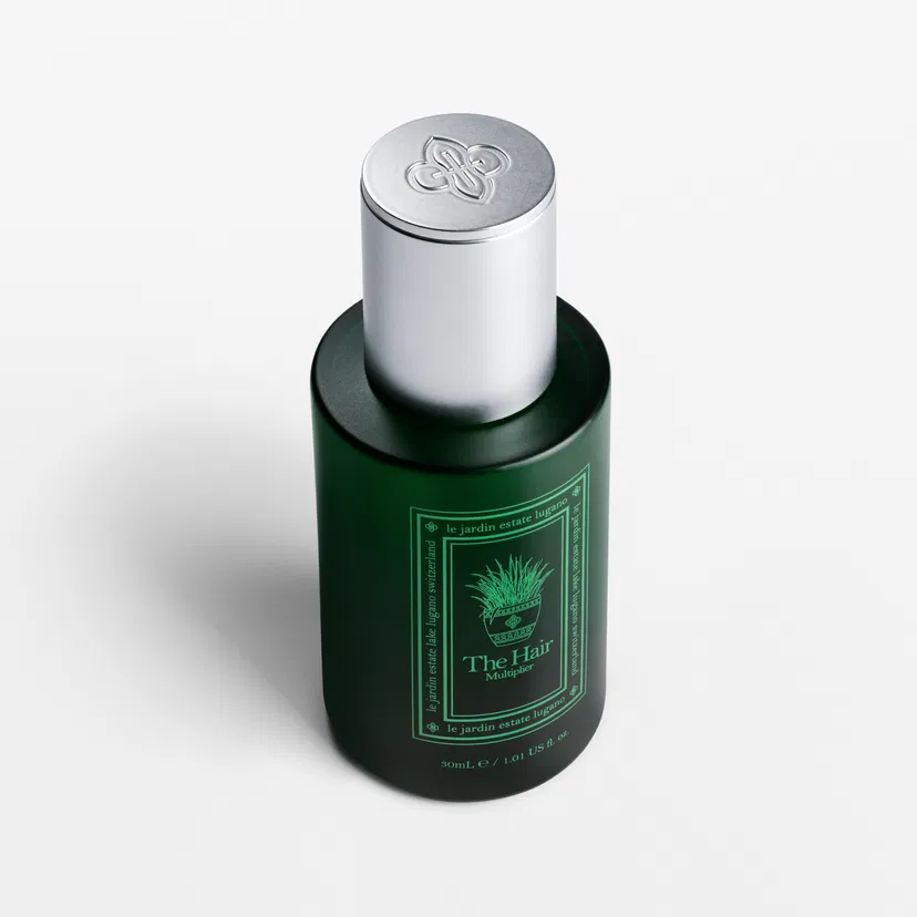 The Hair Multiplier bottle seen from above with embossed silver cap