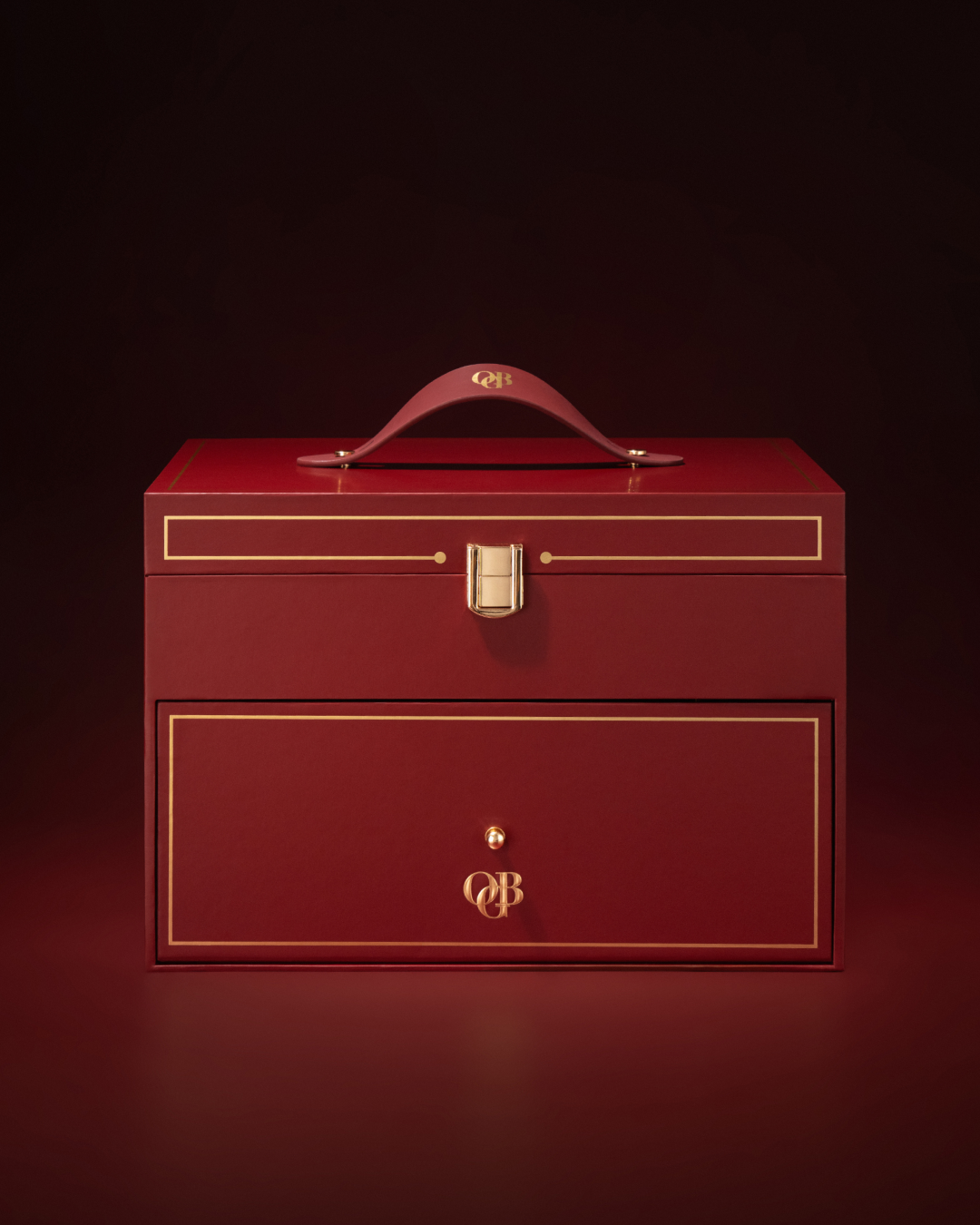 The OGB Vanity Advent Calendar on stacked crimson gift boxes with a bronze satin ribbon under a warm spotlight