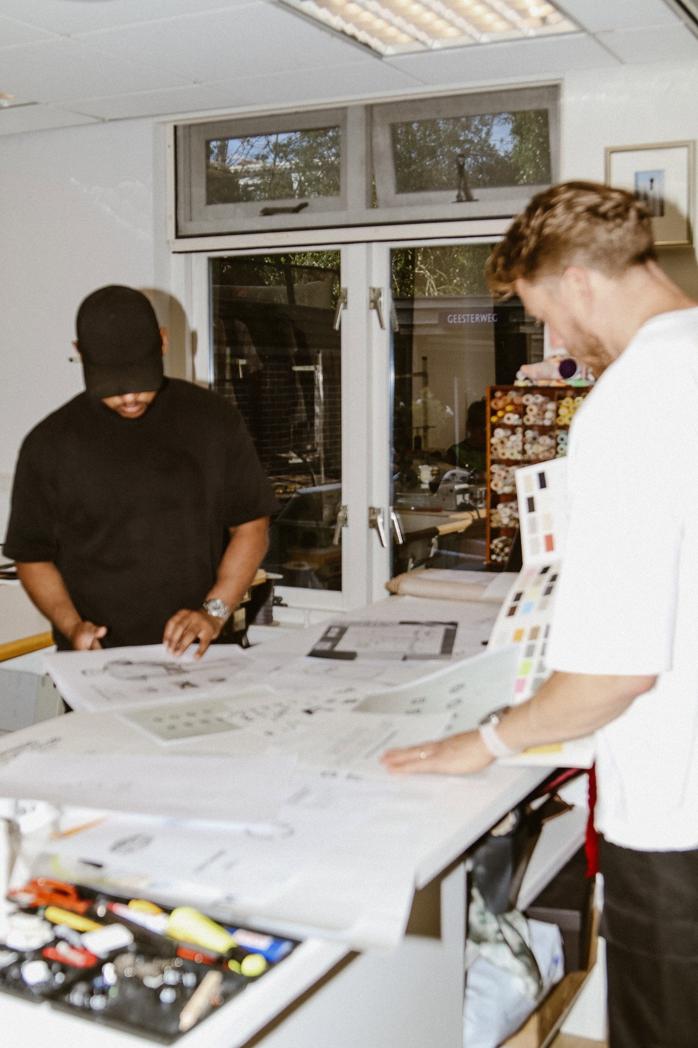 Two designers reviewing patterns and colour swatches in the studio