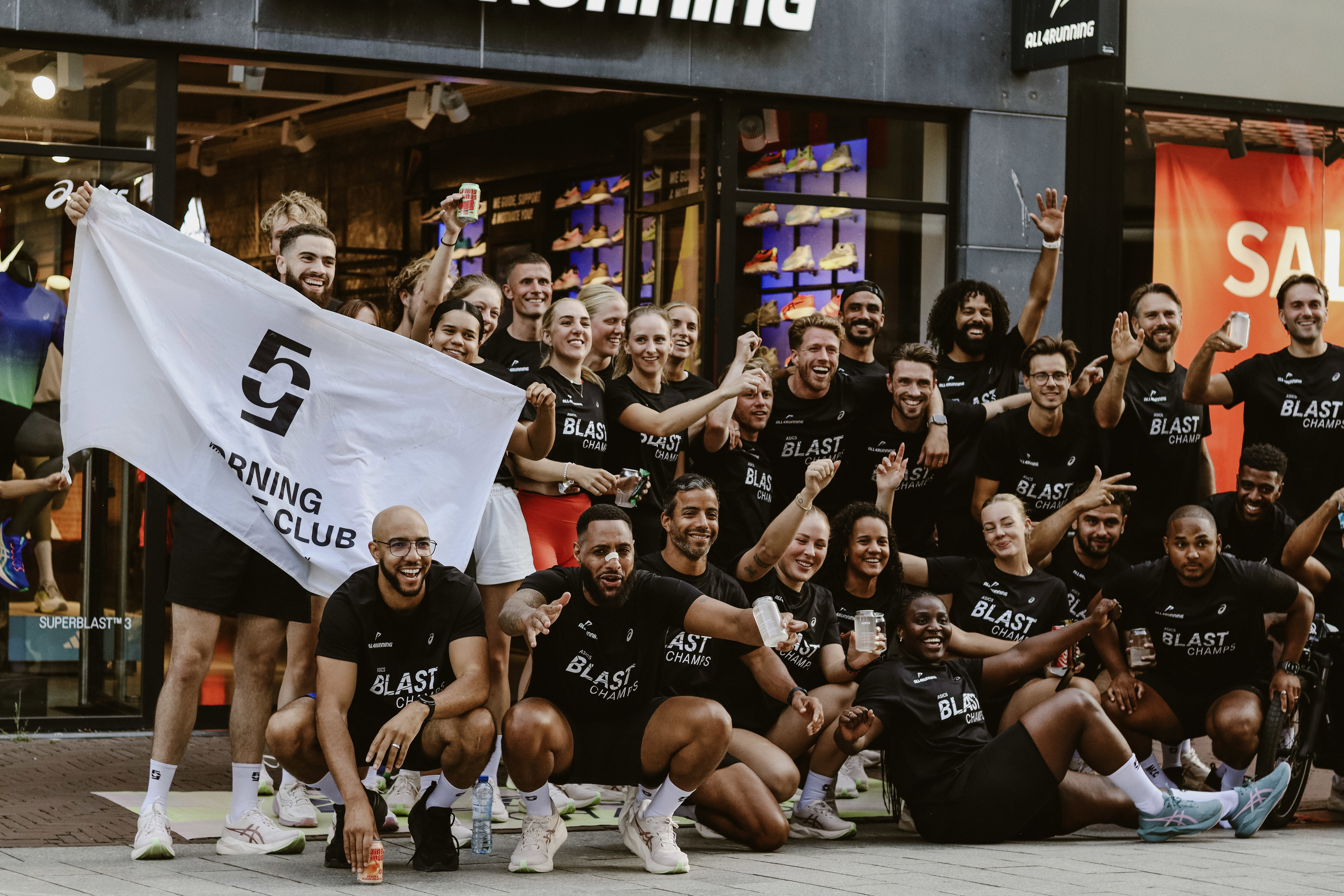 Morning Culture Club crew posing with a club flag at the MCC x ASICS event