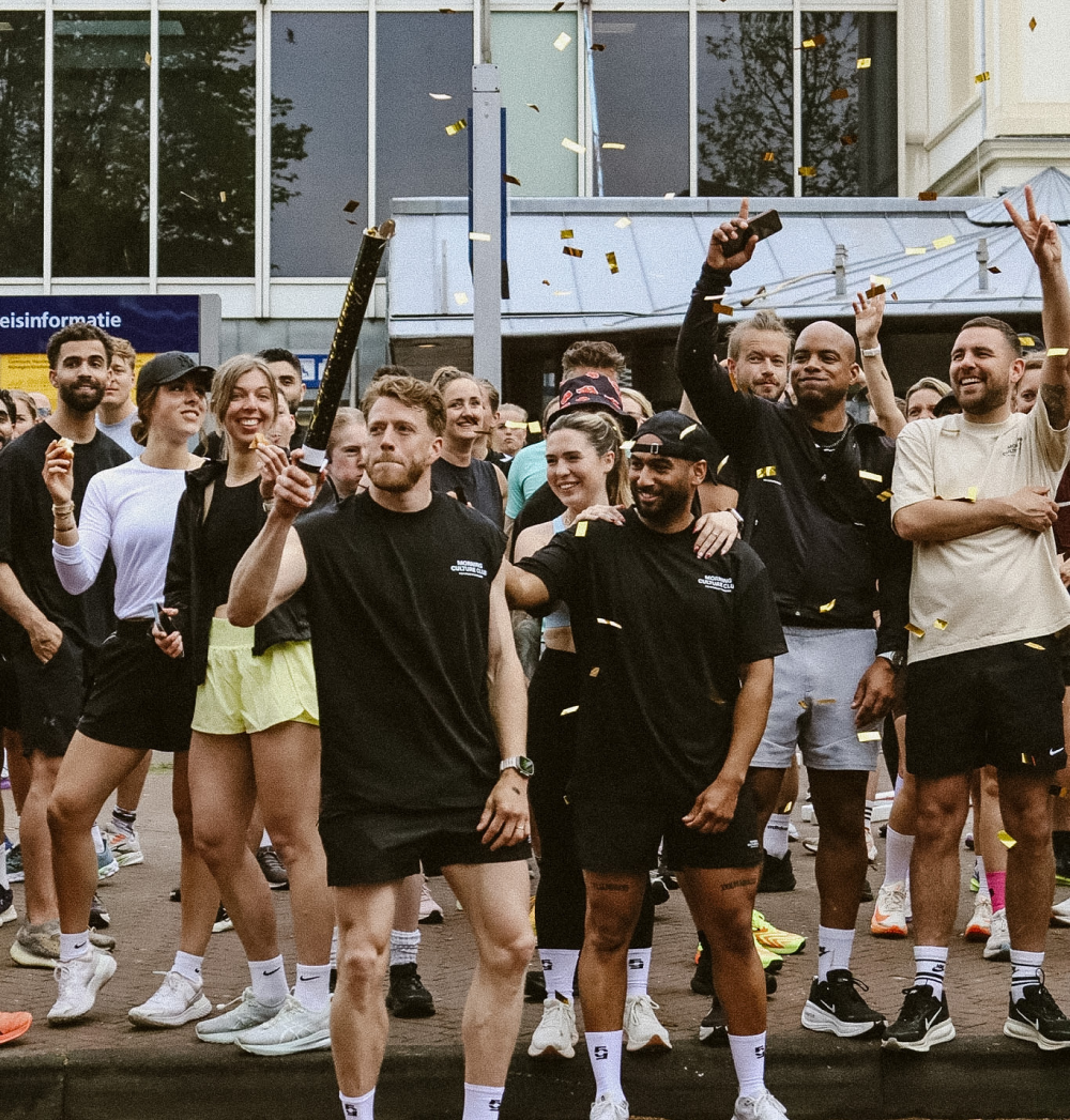 Four people in black training clothing on concrete steps after a morning workout at dawn