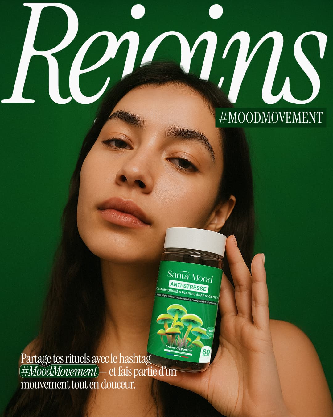 Person holding a bottle labeled &quot;Santa Mood Anti-Stress&quot; against a green background.