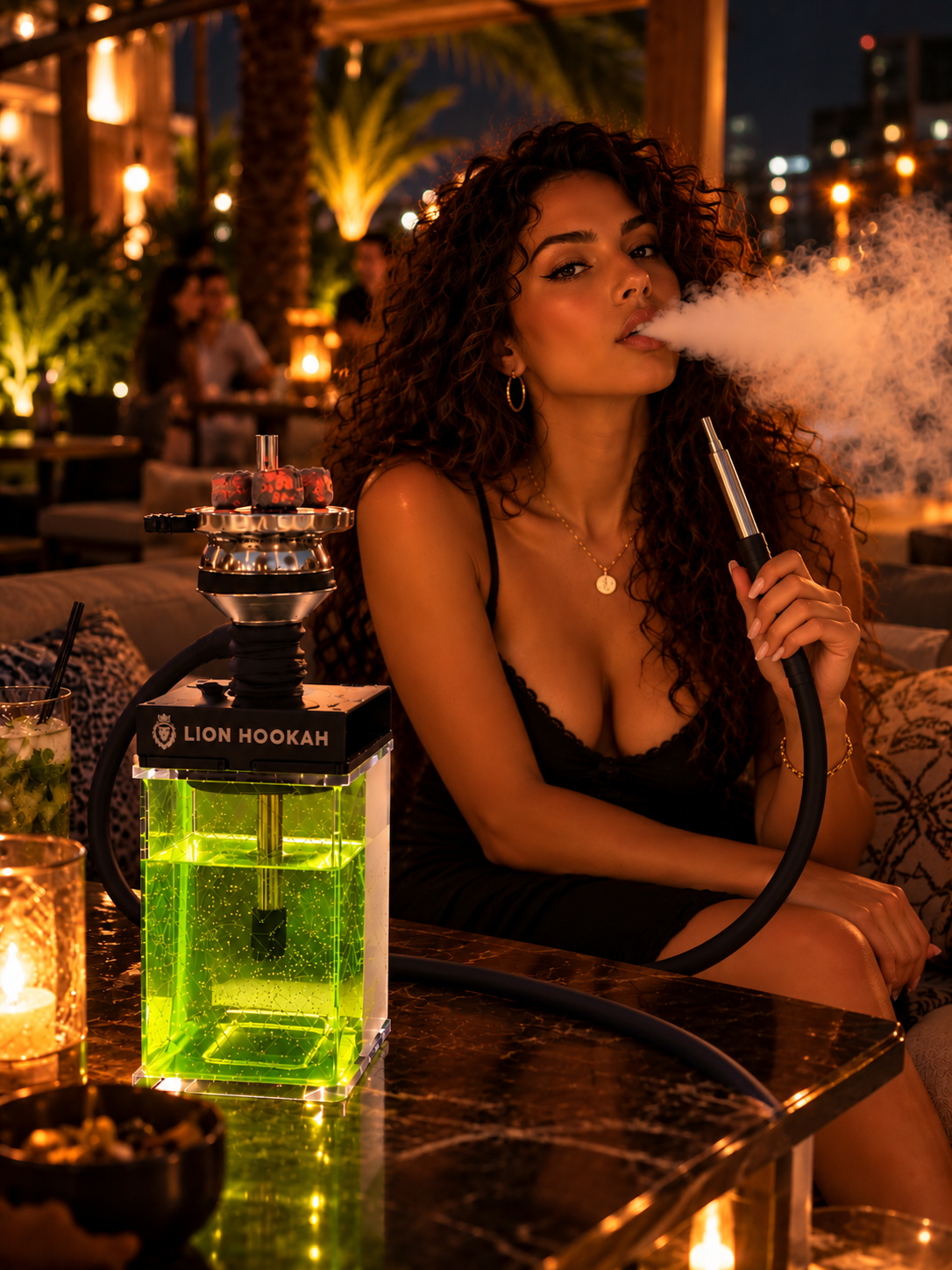 Woman exhaling a cloud of smoke beside the Lion Hookah Square glowing lime green on a marble table in a candlelit rooftop lounge at night