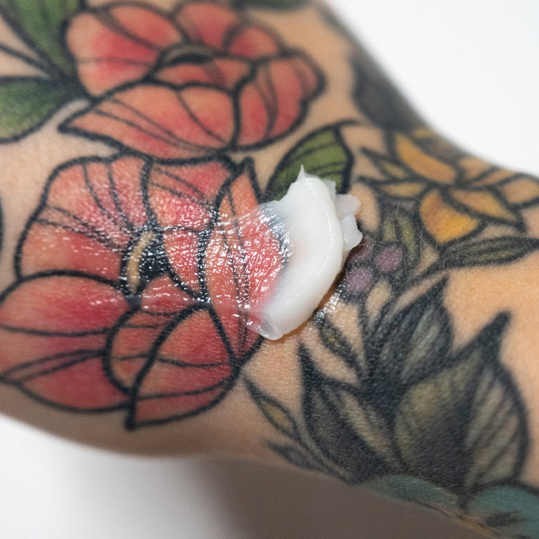 Close-up of a colourful floral tattoo moisturised with Tattoo Butter