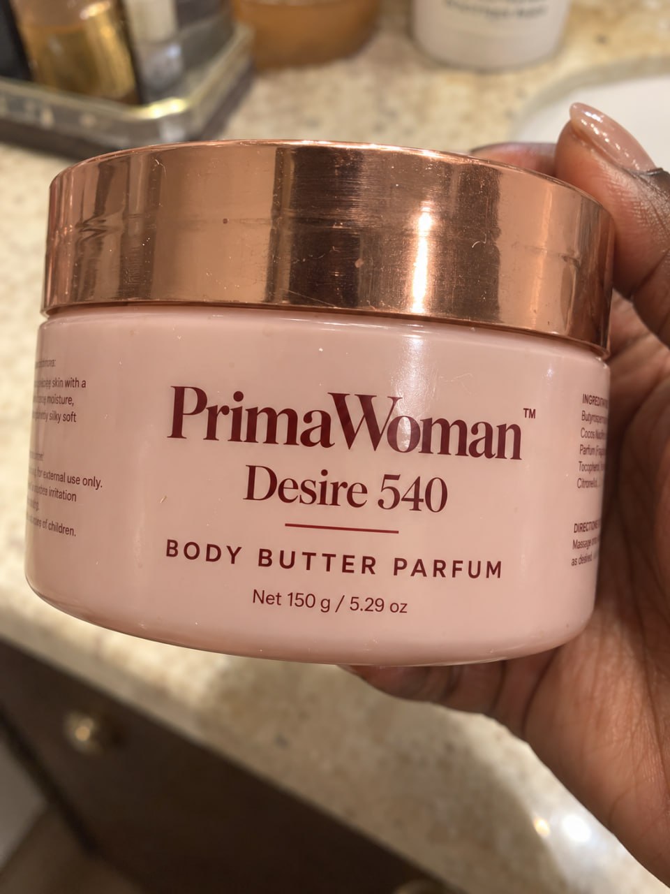 Customer holding her body butter jar in the bathroom