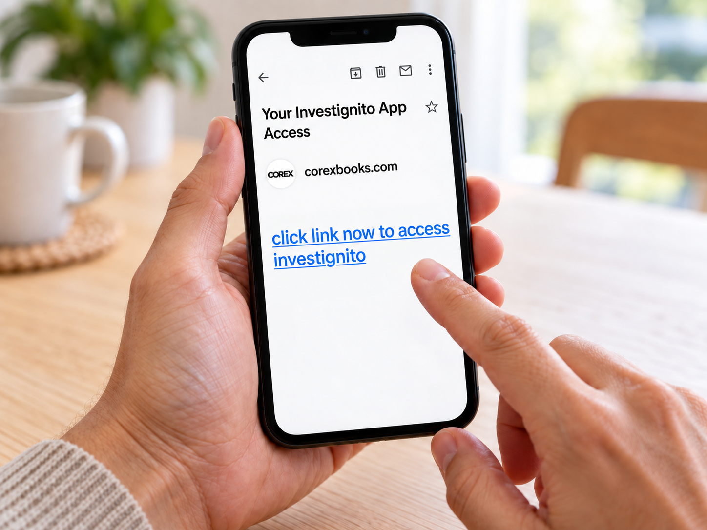 Hand holding a phone showing the Your Investignito App Access email from corexbooks.com with a link to open Investignito