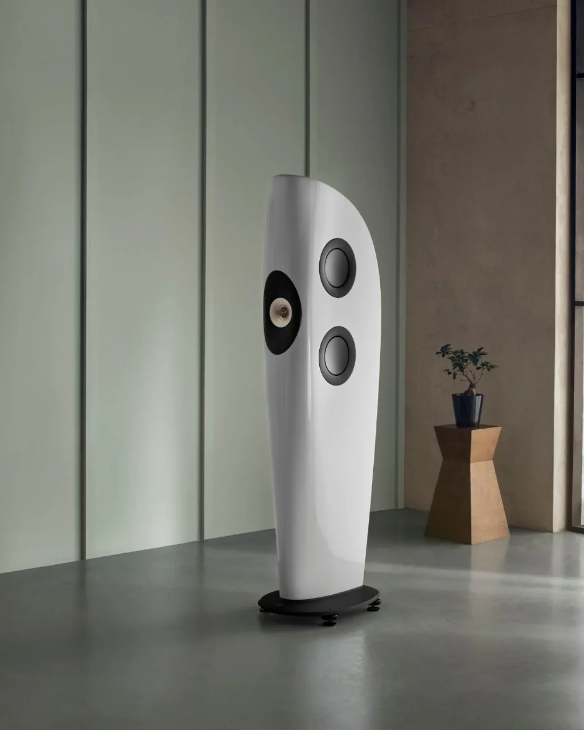 White KEF Blade floorstanding speaker with its Uni-Q driver on the front and side-mounted bass drivers, in a minimalist room