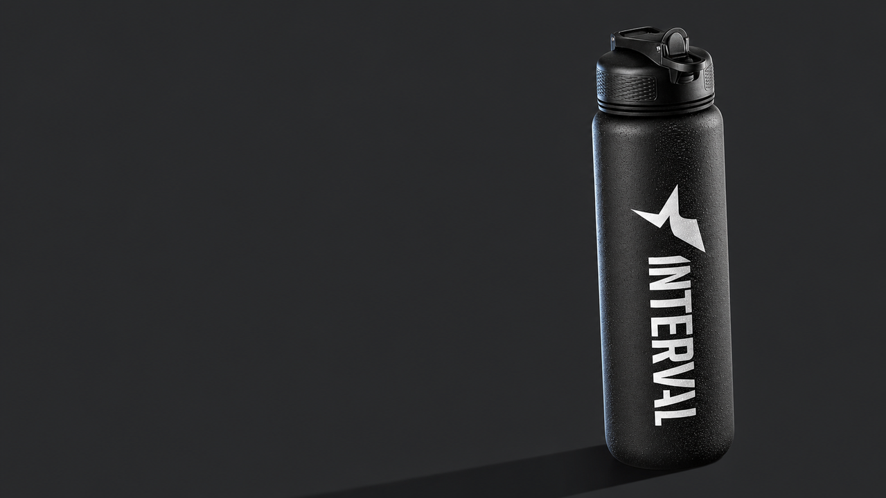 A black water bottle with a star logo and the word Interval on it against a dark background