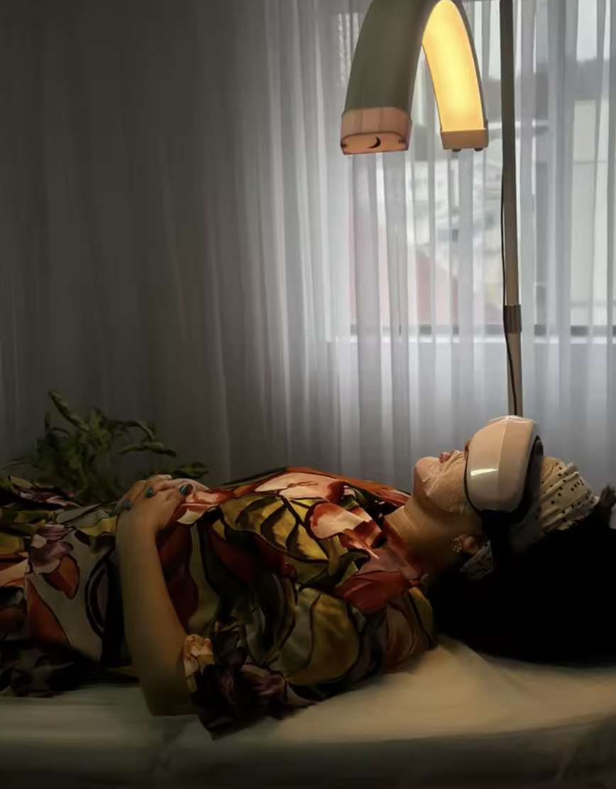 A woman relaxing in bed in the evening wearing EyeCloud