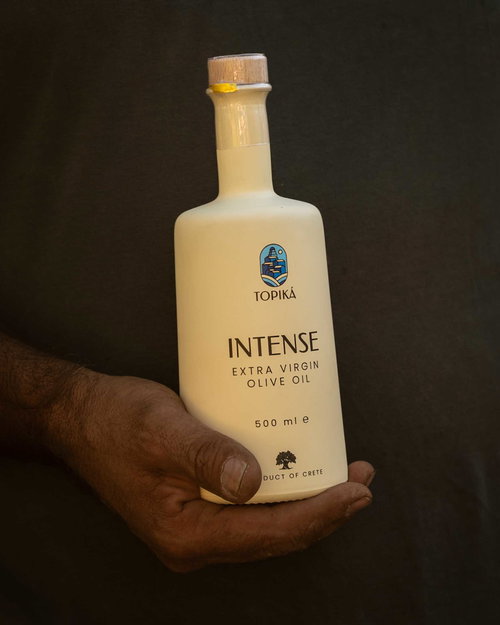 Hand met een fles TOPIKÁ Intense olijfolie