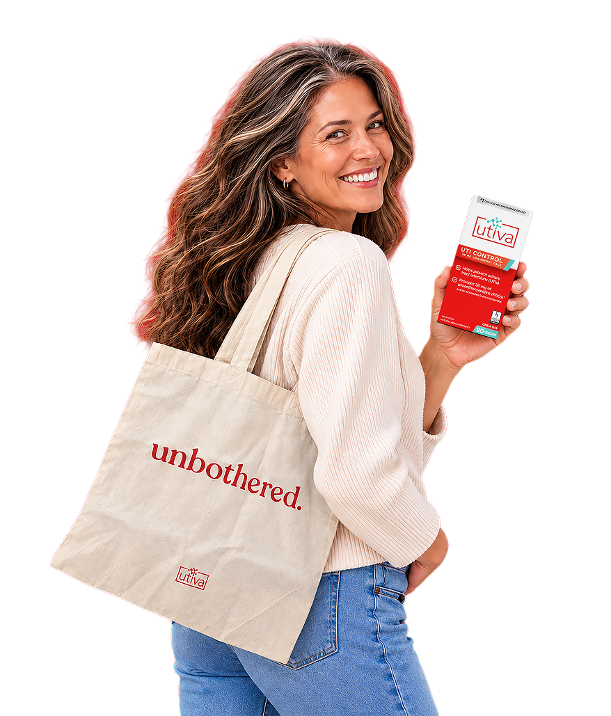 Smiling woman with a Utiva canvas tote on her shoulder holding up a box of UTI Control