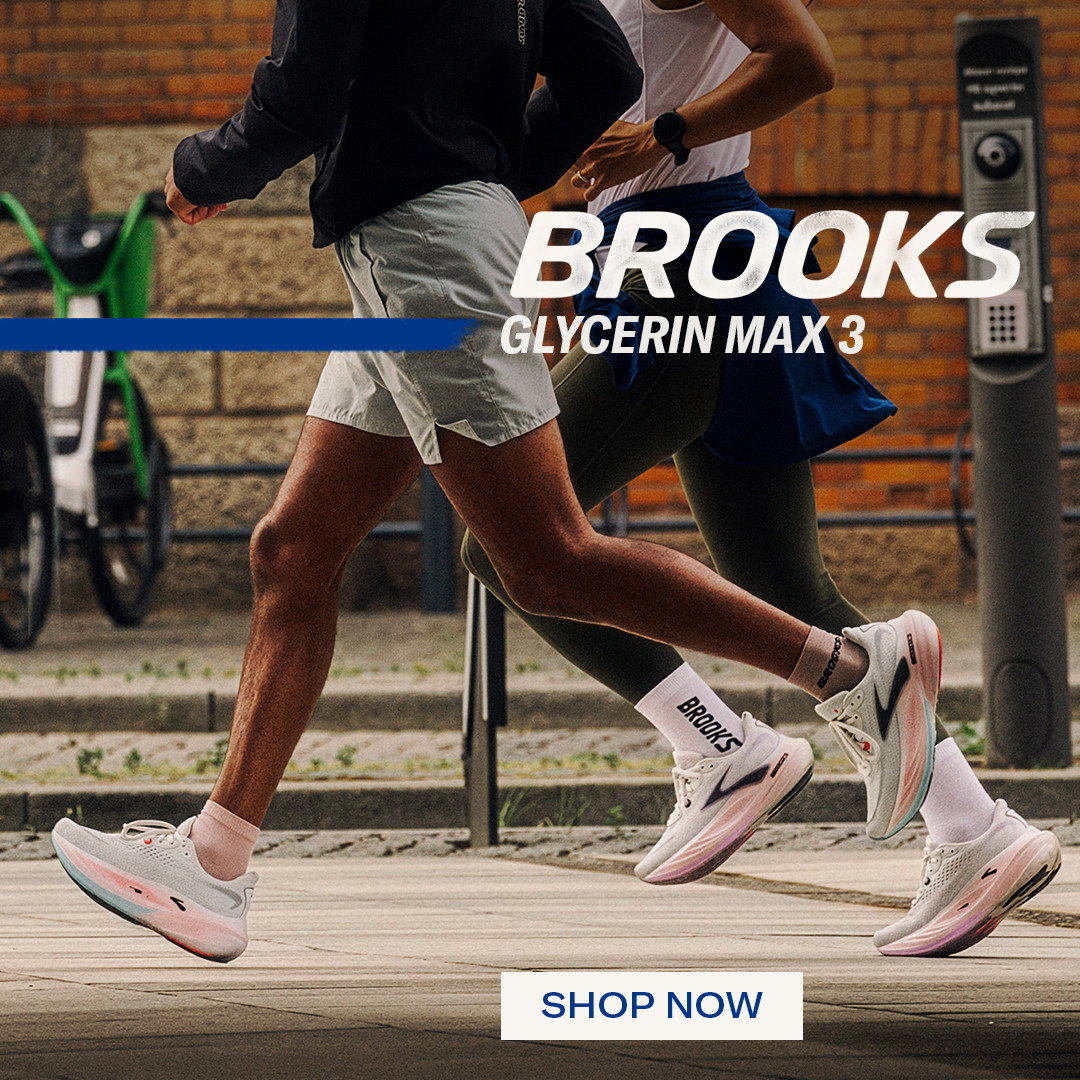 Runners in white Brooks Glycerin Max 3 shoes striding past a brick wall