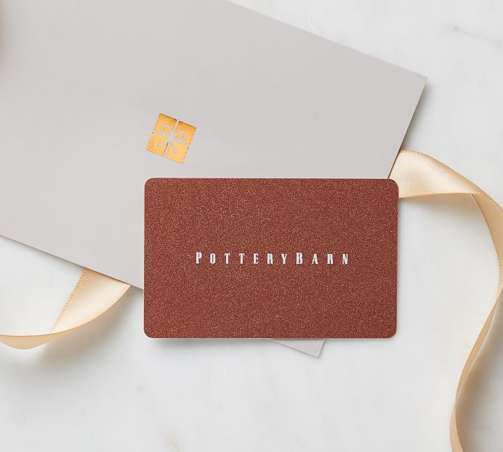 Copper Pottery Barn gift card on a grey gift envelope with a gold ribbon on white marble