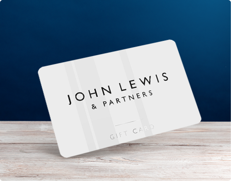 White John Lewis & Partners gift card leaning on a wooden surface against a navy background