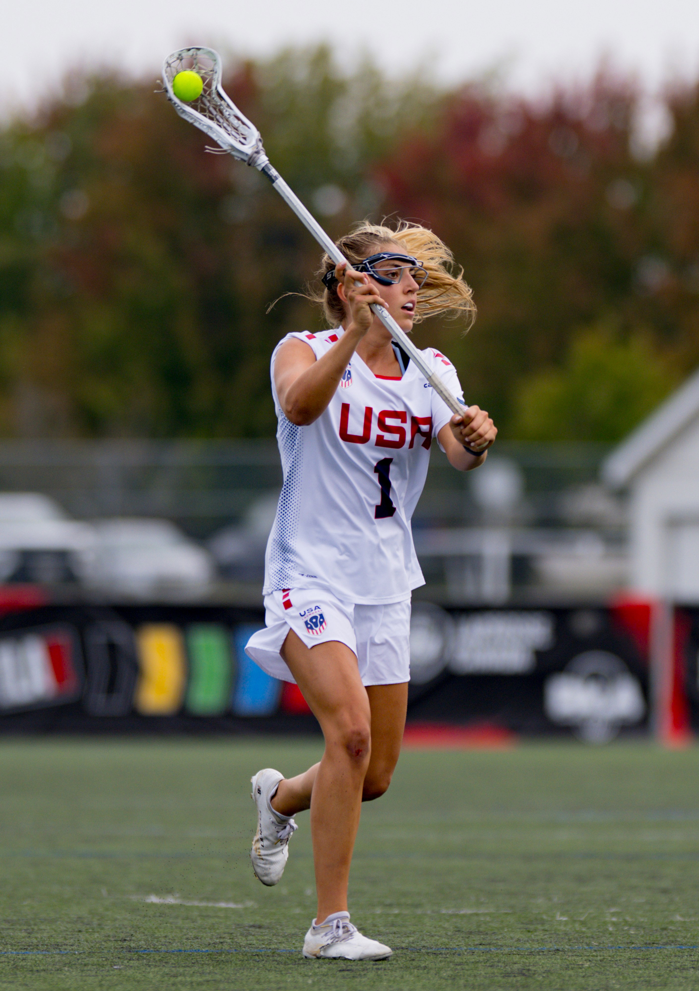 Chloe Humphrey in her Team USA jersey cradling the ball high in her white Crux Pro