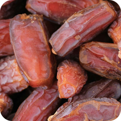 Close-up of several reddish-brown dried dates with wrinkled skin.