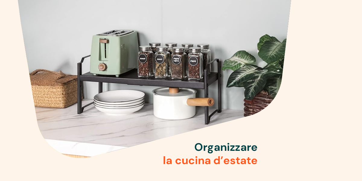 Piano cucina organizzato per l’estate con spezie in barattolo, tostapane verde e pentola: idee pratiche per uno spazio ordinato e fresco.