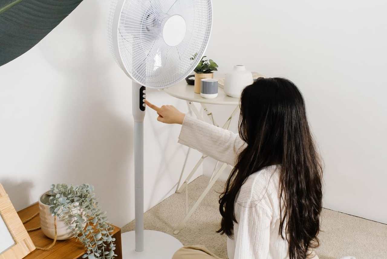 Donna accende un ventilatore a piantana in casa: un piccolo gesto quotidiano consigliato da Mamma Avilia per mantenere freschi gli ambienti in modo semplice.