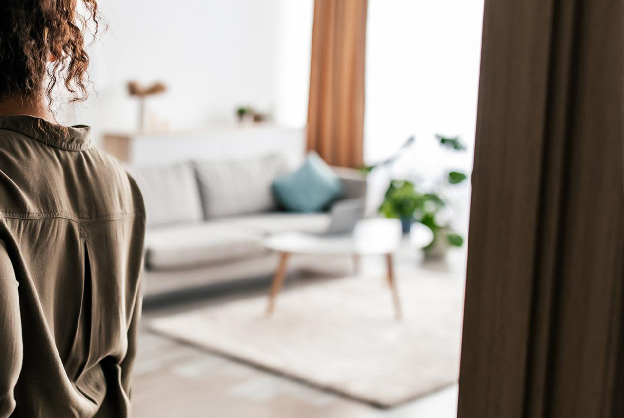 Donna controlla il salotto ordinato prima di uscire di casa per partire in vacanza.