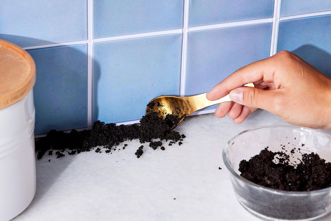 Cucina pulita con fondi di caffè raccolti con cucchiaio: trucco green di Mamma Avilia per eliminare gli odori.