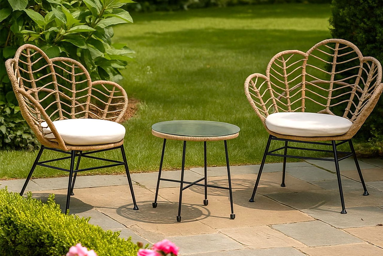 Due poltroncine in fibra naturale con tavolino rotondo su terrazzo verde: angolo estivo perfetto per leggere o rilassarsi secondo Mamma Avilia.