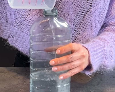 Riempire la bottiglia con acqua per preparare la base dell’ammorbidente fatto in casa, secondo la ricetta di Mamma Avilia.