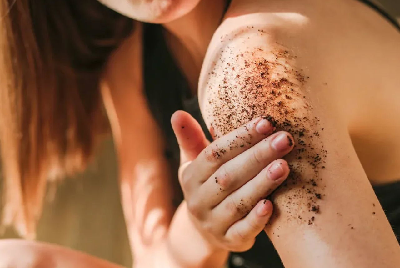 Esfoliazione naturale con fondi di caffè applicati sulla pelle per una beauty routine sostenibile.