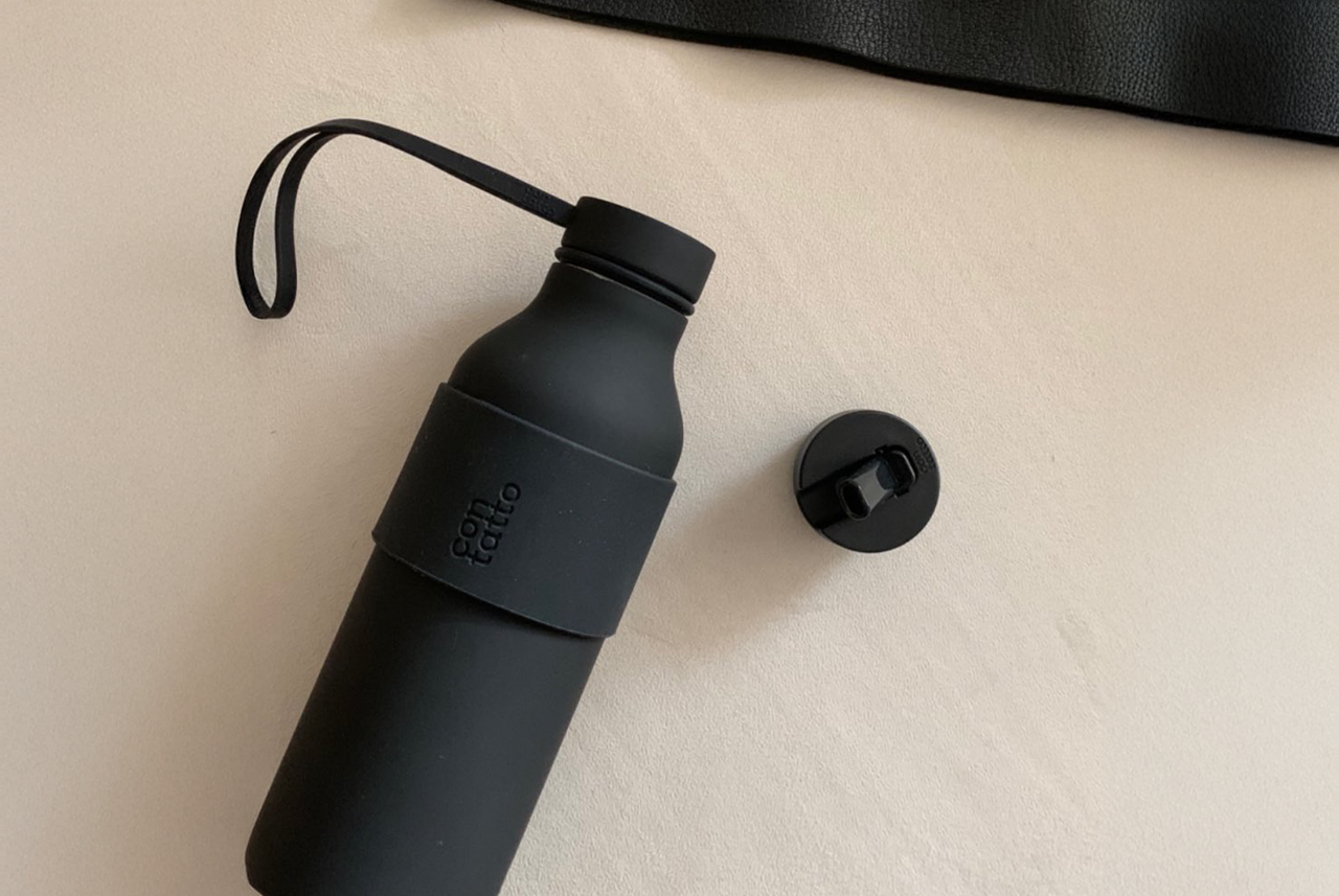 Borraccia nera riutilizzabile su fondo chiaro: un piccolo gesto quotidiano consigliato da Mamma Avilia per ridurre l’uso di plastica e rispettare l’ambiente.