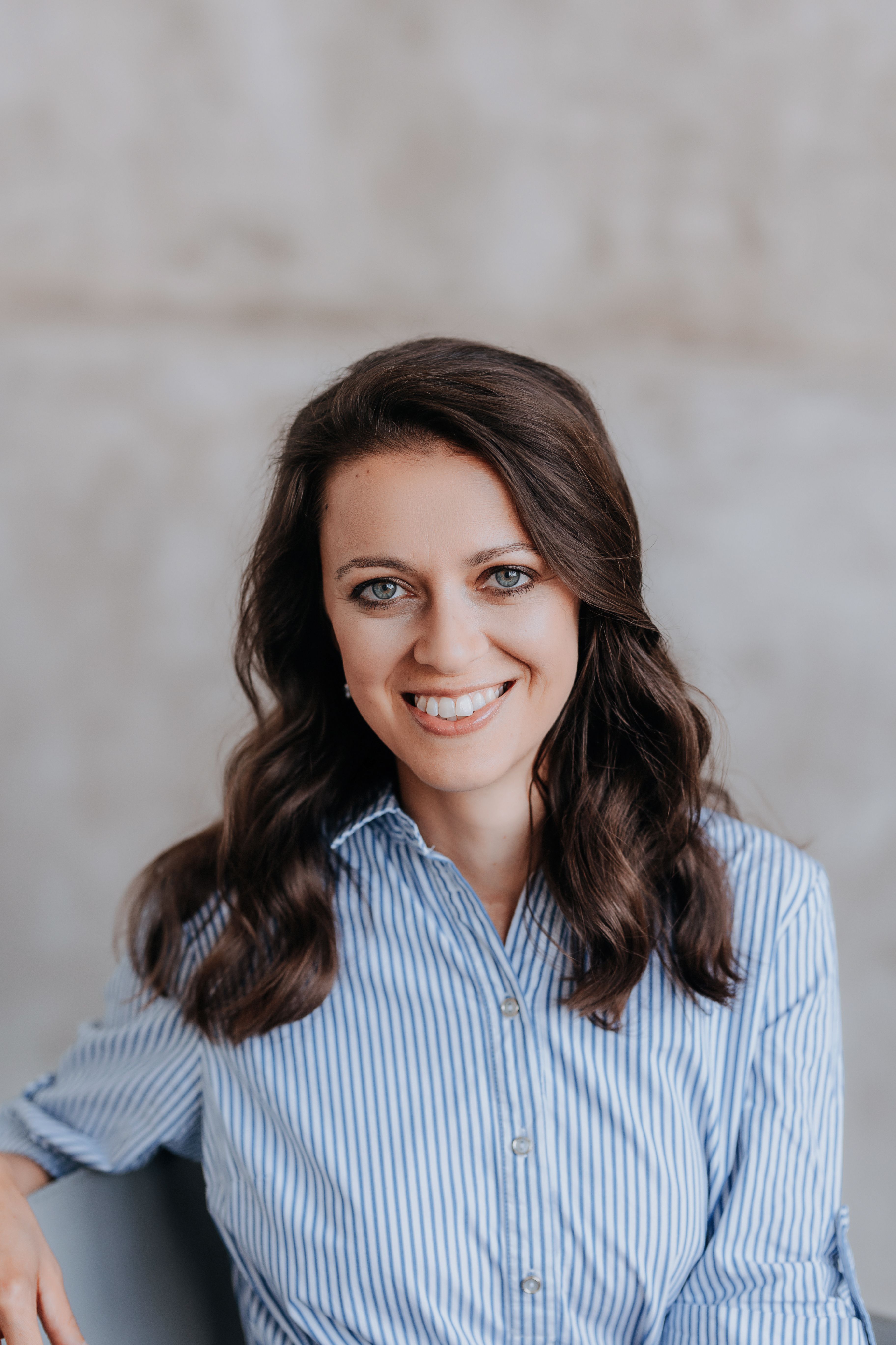 Portrait of Renata Novotna, clinical naturopath at Trime, smiling in a striped blue shirt