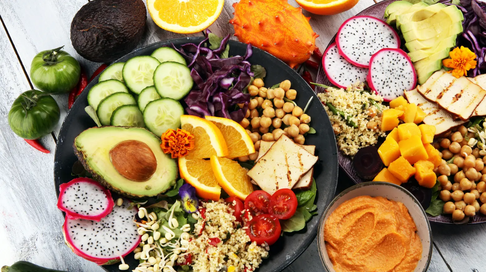 Ein lebendiger Teller mit Avocadoscheiben, Kirschtomaten, Quinoa, Gurken und verschiedenen Obst- und Gemüsesorten.