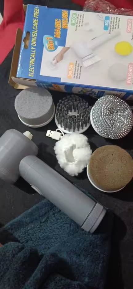 Photo envoyée par un client : la brosse de nettoyage sortie de sa boîte, posée avec ses cinq têtes de brosse et son câble USB