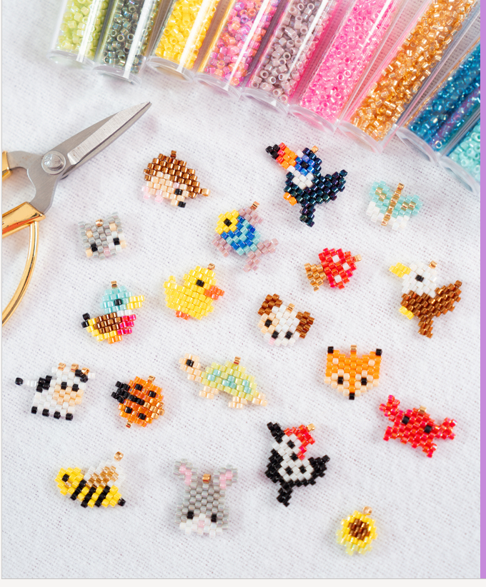 Agrandado Deluxe: charms de animalitos tejidos en mostacilla Miyuki junto a tubos de colores y tijeras doradas