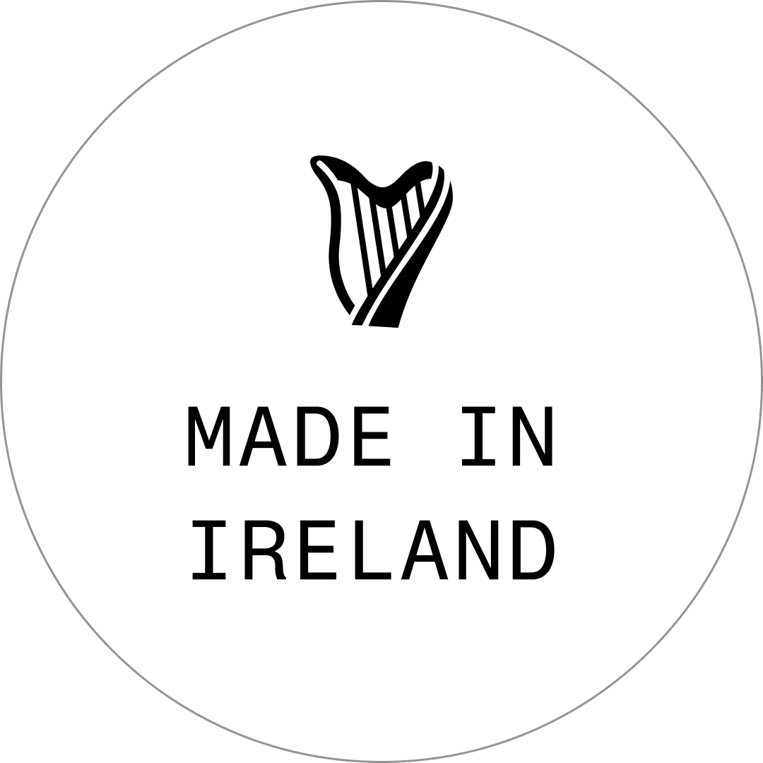 Black harp icon above text &quot;Made in Ireland&quot; on a white circular background.