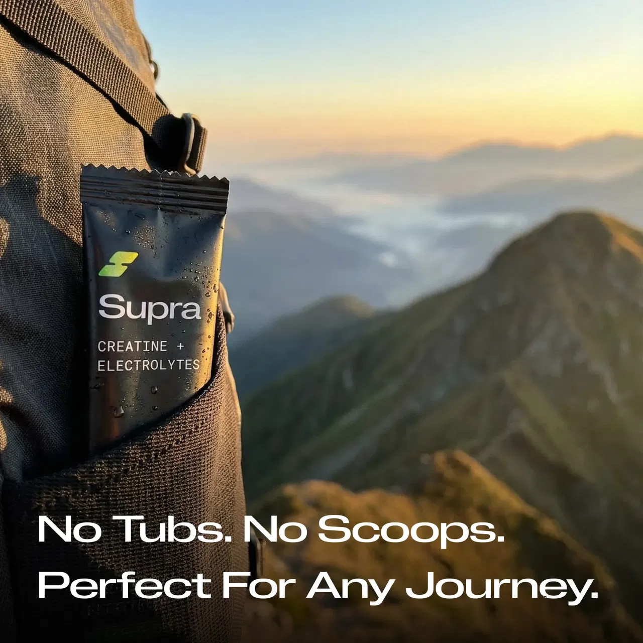 Supra creatine and electrolytes packet in backpack pocket with mountain landscape background.