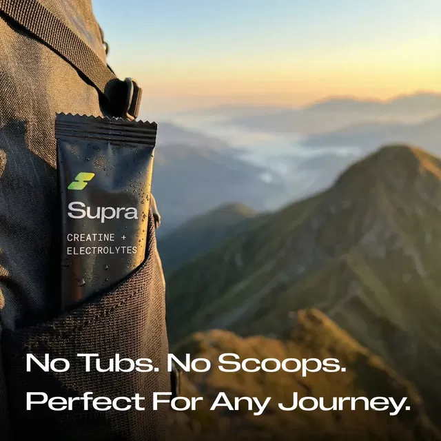 Supra creatine and electrolytes packet in backpack pocket with mountain landscape background.